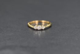 A yellow metal presumed gold diamond chip set trilogy ring, the three graduated diamond chips on