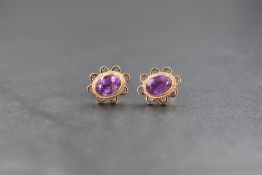 WITHDRAWN A pair of yellow metal presumed gold amethyst stud earrings, the oval cut bezel set