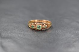 A Victorian 15ct gold emerald and diamond ring, the three graduated square cut emeralds interspersed
