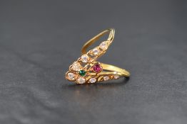 A yellow metal artisan style wishbone ring having a central ruby and emerald style stone within a