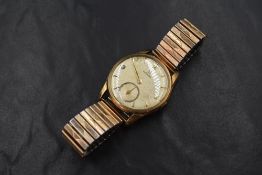 A gent's 1960's 9ct gold Omega manual wrist watch with plated stretch strap, the watch having Arabic