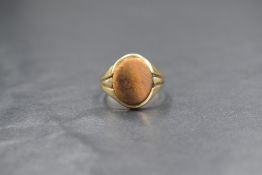 A 9ct gold and tigers-eye gents signet ring, the bezel set oval tigers-eye panel with decorative