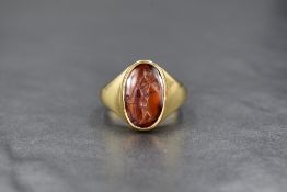 An 18ct gold carnelian intaglio ring, the oval Roman intaglio depicting an unusual version of the