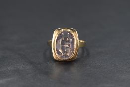 A yellow metal presumed gold amethyst set signet style ring, the oval cut amethyst measuring