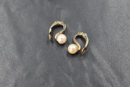 A pair of 9ct gold cultured pearl clip on earrings, the pearls having a white lustre with hinged