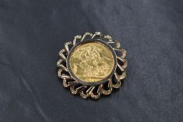 A 1912 sovereign in a removable 9ct gold decorative brooch mount, approximately 35mm diameter & 13.