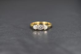 An 18ct gold diamond set trilogy ring, the graduated diamonds measuring between approximately 0.20ct