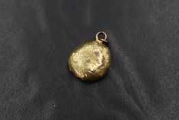 A gold nugget pendant, having two pendant loops marked 9ct with a horseshoe to the reverse, 2cm