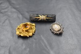 Three damaged antique brooches, including a small white metal one, a mourning bar brooch having