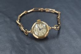 A 9ct gold Johnston & Court Ltd wristwatch, the golden dial having Arabic numerals, on a 9ct gold