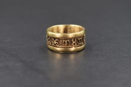 A yellow metal band ring bearing central band of zodiac signs, no marks and acid test inconclusive