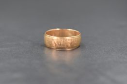 A 9ct gold wedding band having bark effect detail, marked 375, size R & approximately 3.2g