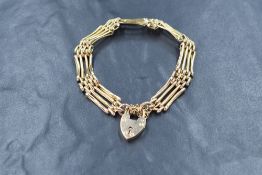 A 9ct gold four bar gate bracelet, having a heart padlock clasp with safety chain, marked 9ct, 10g