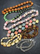 Seven vintage costume jewellery strings of beads including bakelite carved amber style, floral and
