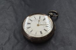 A large Victorian silver key wound pocket watch having a Roman numeral dial on a white enamelled