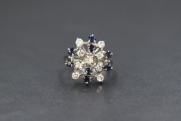 An 18ct gold sapphire and diamond set cluster ring, the nine round cut diamonds interspersed with