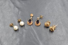 Three pairs of 9ct gold earrings, comprising a pair of knot motif studs, a pair of white lustre
