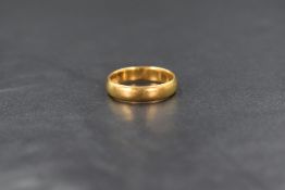 A 22ct gold band, of plain rounded form marked 22 with hallmarks, ring size I-J, 3.5g