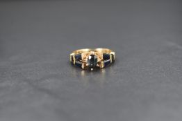A yellow metal ring stamped 14KP, the central oval sapphire measuring approximately 0.30ct within