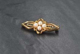 A 9ct gold pearl and sapphire bar brooch, the four central cultured pearls flanked by three round