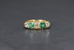 An 18ct gold diamond and emerald five stone set ring, the three old cut diamonds measuring between
