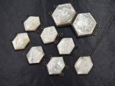 A selection of Chinese white metal and carved mother-of-pearl belt panels ad buckle, all engraved