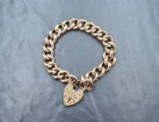 A 9ct rose gold curb link bracelet, having a heart padlock with decorative scroll engraving and