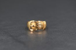 A Victorian 18ct gold buckle ring, the raised buckle design inset with small star set diamond,