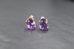 A pair of 9ct white gold amethyst stud earrings, having oval amethysts each measuring