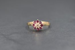 A 9ct gold diamond and ruby set cluster ring, the central illusion set diamond chip, within an eight