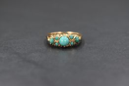 A 9ct gold and turquoise set ring, having a central cabochon flanked by a trio of smaller