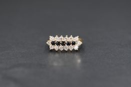 A 9ct gold sapphire and cubic zirconia set cluster ring, the five round cut blue sapphires in a