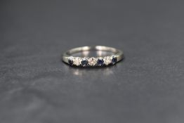 A white metal presumed gold sapphire and diamond half eternity ring, the four round cut blue