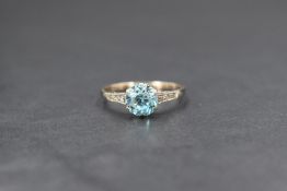 A 9ct white gold blue topaz and diamond set ring, the round cut topaz solitaire measuring