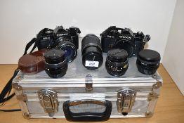 Two Chinon CE-4 camera bodies with RMC Tokina 1:4 25-50mm lens, a SMC Pentax M Zoom 1:4 75-150mm