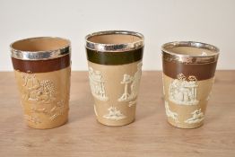 A set of 3 Victorian Royal Doulton Lambeth stoneware beakers, mounted with silver rim dated for