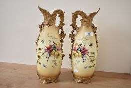 A pair of Turn Wien pottery ewers, hand painted with floral patterns on a blush ivory ground,