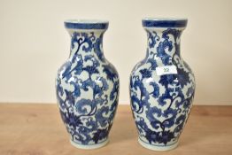 A pair of reproduction Chinese blue and white vases of baluster form, decorated with leafy branches,