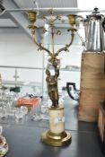 A gilt bronze two stem candelabras having Chinese figure holding a two fluted branch with over-