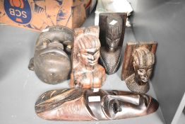 A hand carved wooden African tribal mask, having piercing white eyes, h28cm, sold together with