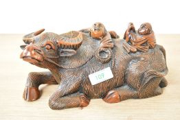 A vintage wooden Chinese sculpture of two boys riding a water buffalo, impressed mark to base,
