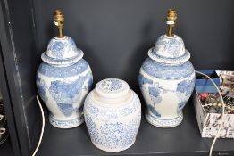 A pair of blue and white ceramic table lamps, decorated with fruit and foliage, h34cm, sold together