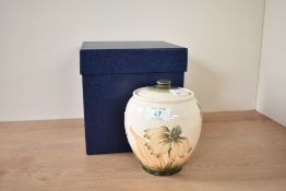 A Moorcroft pottery Cornflower pattern lidded jar, decorated with floral patterns on a cream ground,