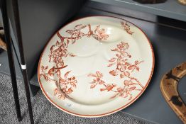 A large Victorian ironstone Turkish plate decorated with red colour birds and foliage on a cream