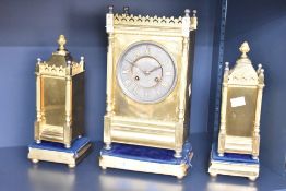 A French 8-day brass mantel clock and garnitures, having brass dial with Roman numerals, mounted