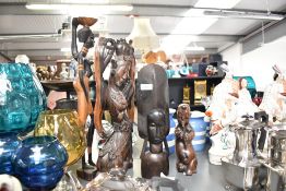 A large Indonesian hand carved hardwood sculpture, h44cm, sold together with a carved wooden child