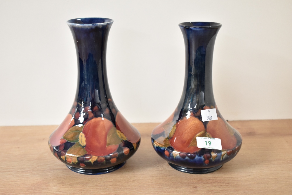 A pair of Moorcroft pottery Pomegranate pattern bottle vases, painted signature and impressed