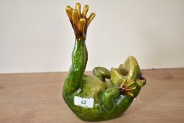 A green ceramic frog on back with legs in air, 15cm x 22cm