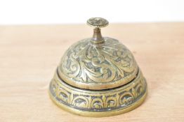 An early 20th century brass desk bell decorated with acanthus leaf, h6cm