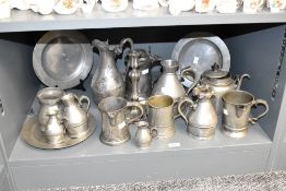 A quantity of pewter tankards of various sizes, largest h13cm, sold together with a candlestick,
